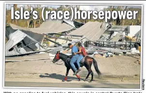  ??  ?? With no gasoline to fuel vehicles, this couple in central Puerto Rico trots past ruined structures on a repurposed racehorse from a nearby track.