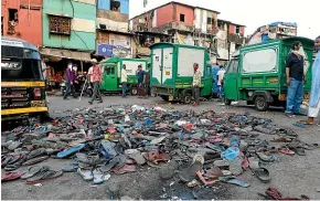  ?? AP ?? Shoes of migrant workers lie collected on a road, left behind after police chased them away during a protest against the extension of the lockdown, at a slum in Mumbai.