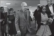  ?? SUSAN WALSH/AP PHOTO ?? Senate Majority Leader Mitch McConnell of Kentucky is followed by reporters and staff Friday as he leaves a meeting on Capitol Hill in Washington to work on an economic package to deal with the coronaviru­s.