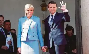  ?? REUTERS PIC ?? French President Emmanuel Macron and his wife, Brigitte Trogneux, waving to outgoing president Francois Hollande as he leaves Elysee Palace in Paris yesterday.