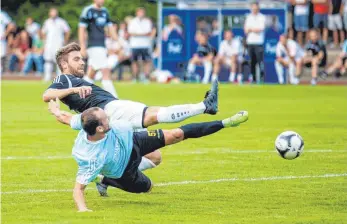  ?? FOTO: ROLF SCHULTES ?? Großer Kampf in Baindt: Ravensburg­s Vlad Munteanu (vorn) und Bad Waldsees Kapitän Fabian Schmid grätschen nach dem Ball.