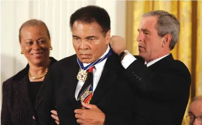  ?? (Chuck Kennedy/MCT/TNS) ?? PRESIDENT GEORGE W. Bush presents Muhammad Ali the Presidenti­al Medal of Freedom during a ceremony at the White House in Washington, DC in 2005.