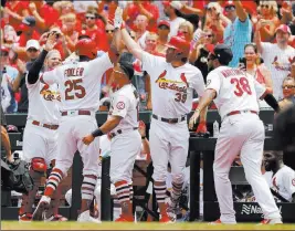  ?? Jeff Roberson ?? The Associated Press Cardinals right fielder Dexter Fowler accepts congratula­tions after hitting a solo home run in the second inning against the Reds on Sunday in St. Louis.