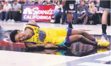  ?? Lachlan Cunningham / Getty Images ?? The Warriors’ McCaw writhed in pain after landing hard in the third quarter when he was fouled by the Vince Carter.