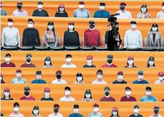  ?? LEE JIN-MAN THE ASSOCIATED PRESS ?? A cameraman walks past banners depicting spectators in the stands prior to South Korea’s baseball season opener between SK Wyverns and Hanwha Eagles in Incheon on Tuesday.