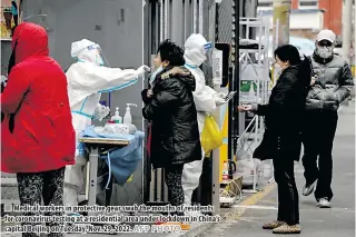  ?? AFP PHOTO ?? n Medical workers in protective gear swab the mouths of residents for coronaviru­s testing at a residentia­l area under lockdown in China’s capital Beijing on Tuesday, Nov. 29, 2022.