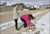  ?? LAURA SEITZ — THE DESERET NEWS VIA AP ?? Alecia Jones, right, with her daughter Brooklyn, 13, places a Minnie Mouse stuffed animal by police tape near a home where eight members of a family were killed in Enoch, Utah, on Thursday. Brooklyn was friends with one of the victims.