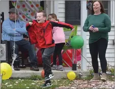  ?? PETE BANNAN - MEDIANEWS GROUP ?? Ten year-old Ryan McCauley reacts to his drive-by birthday party Tuesday. With him are his dad, Dan, sister, Kylie, and mother Kate McCauley.