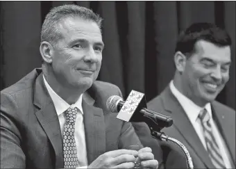  ?? JAY LAPRETE/AP PHOTO ?? Ohio State football head coach Urban Meyer, left, answers questions during Tuesday’s news conference announcing his retirement in Columbus, Ohio. At right is assistant coach Ryan Day, who will take over as head coach.