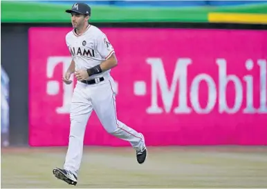  ?? WILFREDO LEE/AP ?? Steve Lombardozz­i warms up Wednesday before the start of his first major league game since 2015. He was called up after a rare string of injuries to the Marlins’ infield.