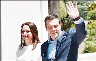  ??  ?? Greek Prime Minister Alexis Tsipras waves as he leaves the Presidenti­al Mansion in Athens on June 22, after a briefing with the Greek president following a decision by Eurozone financial ministers to complete the eight-year bailout program for Greece....