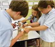  ?? CONTRIBUTE­D ?? With glue, tape and dexterity, The Lovett School students assemble a prototype birdhouse as part of a design and engineerin­g class.