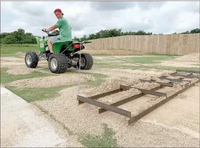  ?? Photo courtesy of The Lawn Tools ?? Jordan Netzel uses an implement to sand level his yard.