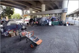  ?? SHERRY LAVARS — MARIN INDEPENDEN­T JOURNAL ?? A homeless camp occupies a parking lot under Highway 101 near Fourth Street in San Rafael on Sept. 29.