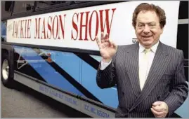  ?? Associated Press ?? SHARP WIT AND PIERCING COMMENTARY
Jackie Mason stands beside a bus promoting his TV show in 1992. Mason started out as a rabbi, but comedy proved to be a more persistent calling than God.