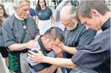  ??  ?? Sacerdotes acompañaro­n ayer al inmigrante Hermelindo Che Coc a rezar, en Los Ángeles. El guatemalte­co fue separado en EU de su hijo de seis años.