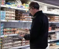  ?? (File Photo/AP/Nam Y. Huh) ?? A shopper checks eggs Jan. 10 before he purchases them at a grocery store in Glenview, Ill.