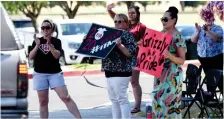  ?? RECORDER PHOTO BY NAYIRAH DOSU ?? One group of Granite Hills High School staff cheer on graduates as they exit the Grizzlies’ drive-thru graduation, Wednesday, May 27, 2020.