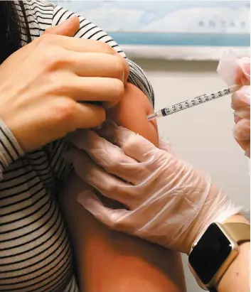  ?? PHOTO AFP ?? Une femme reçoit un vaccin antigrippa­l dans une pharmacie de San Francisco.