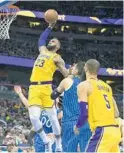  ?? WILLIE J. ALLEN JR./AP ?? Los Angeles Lakers forward LeBron James (23) slams the ball over Orlando Magic center Nikola Vucevic (9) Saturday night at Amway Center.
