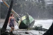  ?? PICTURE: REUTERS ?? A resident walks past a yacht that was washed ashore after Cyclone Debbie hit Airlie Beach today.
