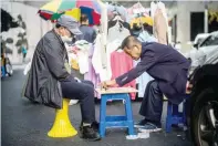  ?? — AFP ?? Men play a game of Janggi, also known as Korean chess, on a street in Seoul on Wednesday.