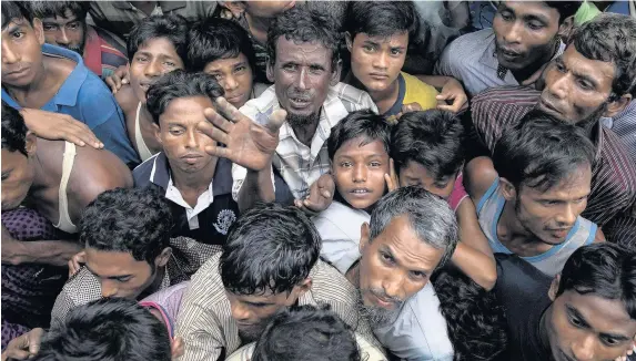  ?? Dan Kitwood ?? > Rohingya refugees wait for sacks of rice to be distribute­d in Whaikhyang, Bangladesh