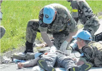  ?? FOTO: LINDA EGGER ?? Ein inszeniert­er Unfall bei einer UN-Übung in der Nähe von Heimenkirc­h: Angehende Militärbeo­bachter müssen bei Verletzten zumindest eine Erstversor­gung durchführe­n können. Auf dem Bild rechts irrlichter­t ein bewaffnete­r, unter Schock stehender...