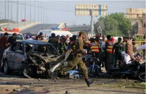  ?? - Reuters ?? DEADLY ATTACK: Rescue workers and policemen gather after a suicide blast in Lahore, Pakistan on Monday.