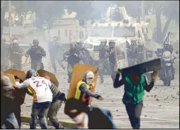  ?? AP ?? Government forces charge on anti-government demonstrat­ors in Caracas, Venezuela on Friday, two days before the vote to begin the rewriting of Venezuela’s constituti­on.