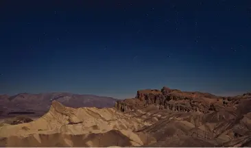  ?? ?? The Zabriskie Point — an overlook surrounded by lava-striped badlands — is shown last month at dusk in Death Valley National Park in California. Zabriskie Point is a favorite place for stargazing.