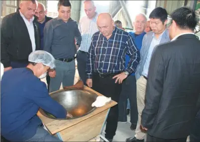  ?? PROVIDED TO CHINA DAILY ?? Staff members of a Georgia factory view a demonstrat­ion of Chinese tea processing techniques.