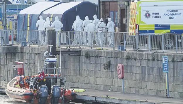  ?? ?? ↑ Forensic officers head to the RNLI station at the Port of Dover to examine the bodies of victims after a migrant boat capsized in the Channel