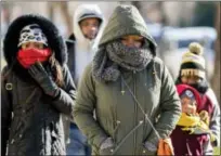  ?? ASSOCIATED PRESS ?? A family braves temperatur­es in the teens as they make their way to the National Museum of African American History and Culture on the National Mall in Washington.