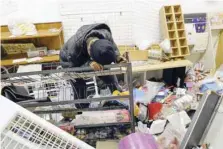  ?? — AFP ?? A shop owner weeps inside her looted store at the Diepkloof Square area in Soweto, Johannesbu­rg on Tuesday.
