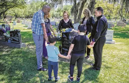  ?? Photos by Marie D. De Jesús / Staff photograph­er ?? Top: Jamail Amron’s family gathers in prayer around his grave in Aldine last week. He was 23 when he died.