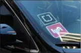  ?? AP FILE ?? A car displays Uber and Lyft stickers in January 2016 in downtown Los Angeles.