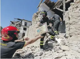  ?? ANDREW MEDICHINI / THE ASSOCIATED PRESS ?? Firefighte­rs retrieve a painting from a church in the small town of Rio, near Amatrice, central Italy, which was hit by a devastatin­g earthquake last week.