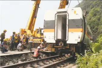  ?? Chiang Ying-ying / Associated Press ?? Repair crews work to remove a carriage from the train that derailed near Taroko Gorge in Taiwan. The train struck a truck that had rolled onto the tracks Friday. Dozens were killed.