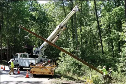  ?? The Sentinel-Record/Richard Rasmussen ?? POWER RESTORATIO­N: Employees of BBC Electric from Joplin, Mo., replace a broken utility pole on Needham Road on Monday. The pole was damaged during severe weather over the weekend.