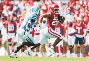  ?? Brian Bahr / Getty Images ?? Oklahoma running back Kennedy Brooks runs with the ball while being pursued by safety Tulane’s Larry Brooks during the second quarter on Saturday in Norman, Okla. Oklahoma won 40-35.