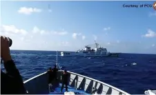  ?? — AFP /Philippine Coast Guard photo ?? A Chinese Coast Guard ship (top) manoeuveri­ng past a Philippine Coast Guard ship near Sandy Cay reef, near the Philippine-held Thitu Island in Spratly Islands.