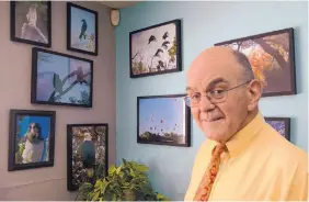  ?? GREG SORBER/JOURNAL ?? Corrales resident Guy Clark is a dentist, anti-gambling activist and bird enthusiast. He is shown here in his West Side dental office with a few of the many photograph­s he has taken of birds and landscapes in the Corrales bosque.