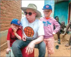  ?? AMOS GUMULIRA/AFP ?? Malawian musician with albinism Lazarus Chigwandal­i poses with his sons Layijo (left) and Joseph.