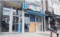  ??  ?? A Toronto police officer walks past Caffe Demetre on Monday.