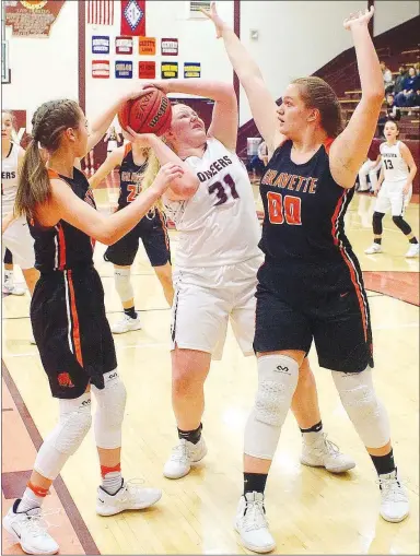  ?? Westside Eagle Observer/RANDY MOLL ?? Emily Toland, a Gentry sophomore, looks to shoot under the basket while being guarded by Gravette’s Maggie McKenzie (left) and Abigail Beranek during the Dec. 18 game at Gentry High School.