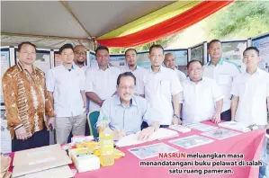  ??  ?? NASRUN meluangkan masa menandatan­gani buku pelawat di salah satu ruang pameran.