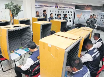  ?? PATTARAPON­G CHATPATTAR­ASILL ?? Immigratio­n police demonstrat­e how suspects worked in sound-proof, makeshift booths as they phoned victims of a call-centre scam, following the recent arrest of 44 Chinese suspects of the gang based in Thailand.