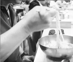  ??  ?? A customer at the Pyongyang Myunok restaurant eats North Korean-style cold noodles.