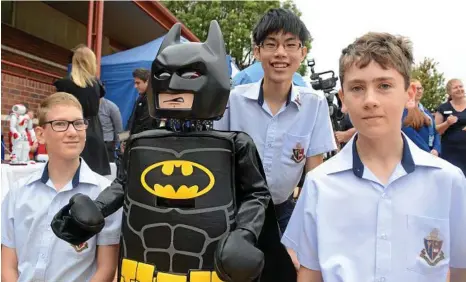  ?? PHOTOS: TOM GILLESPIE ?? RO-BAT: Toowoomba Anglican College students (from left) Maarten Dekeyser, Joseph Goh and Luca Donald with a Mecano robot dressed as Batman at the launch of the Mayor’s Telstra Technology Awards.